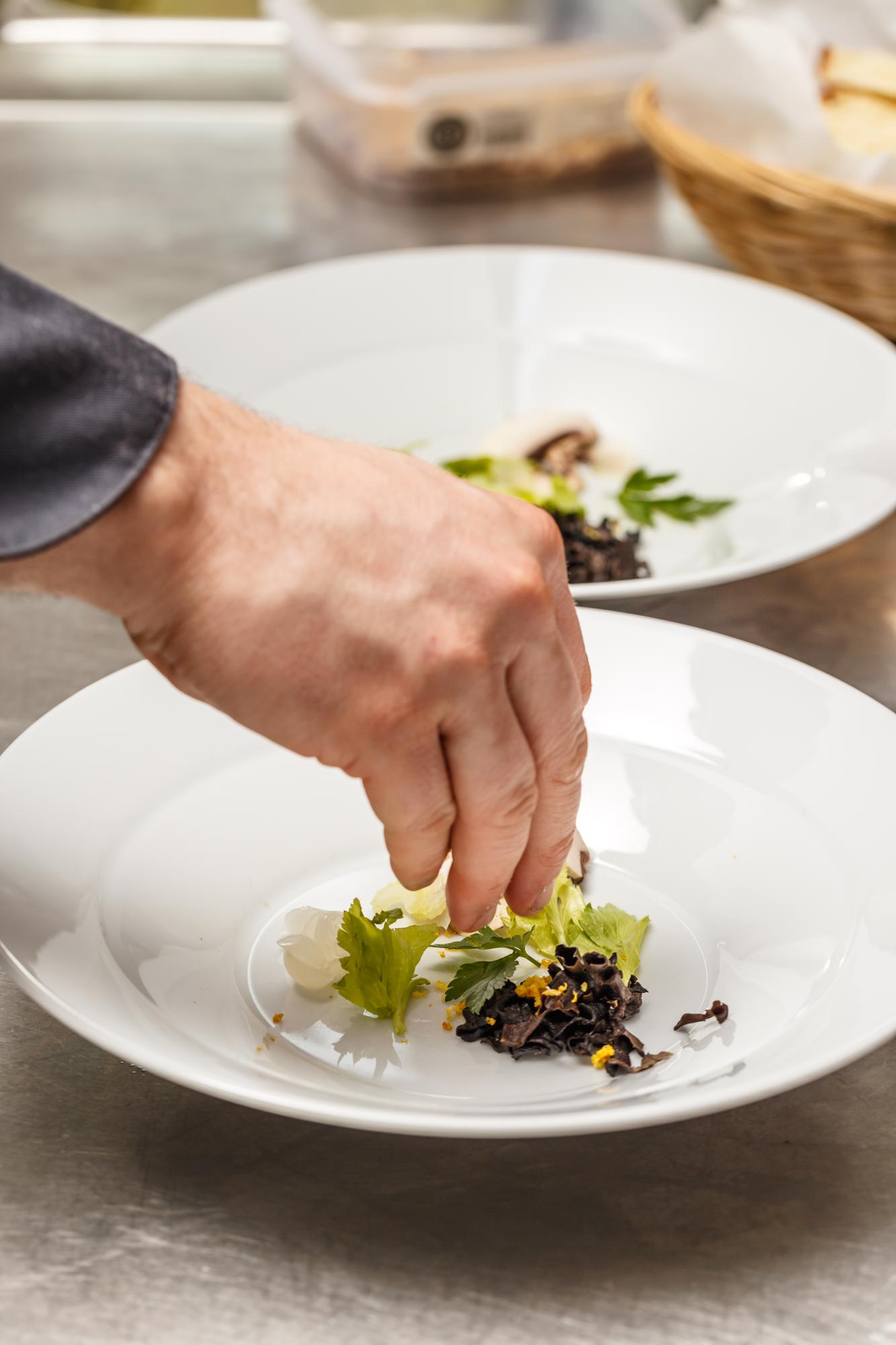 Chef placing finishing touch on plated dish